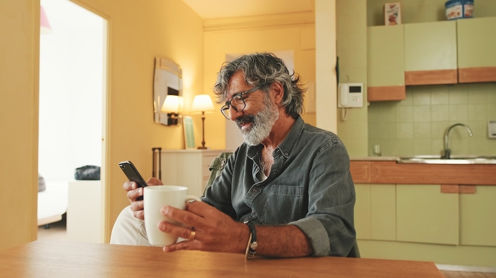 Hombre revisando su teléfono mientras utiliza una plataforma de envío de dinero a México