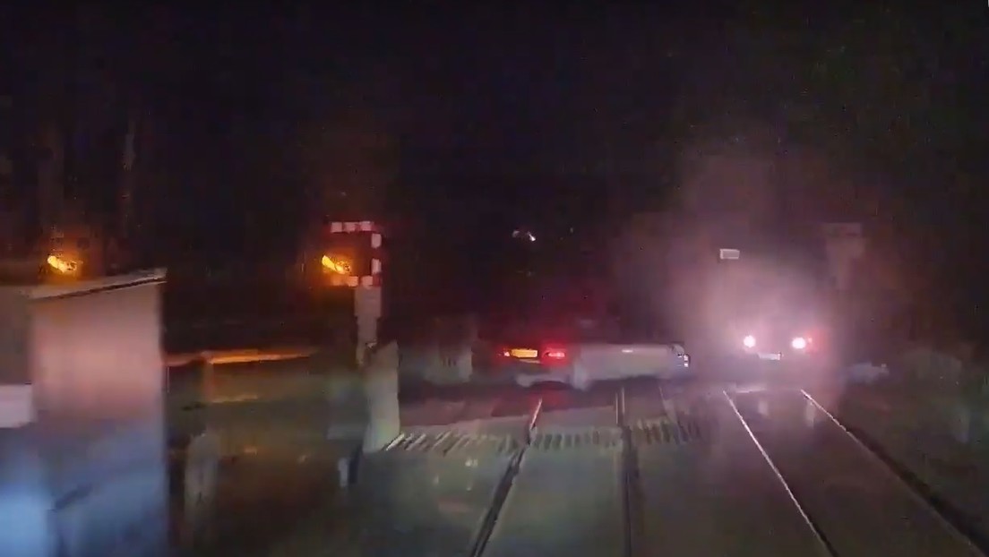 ¡Impactante! Un tren repleto de pasajeros estuvo a punto de impactar contra dos vehículos +Vídeo