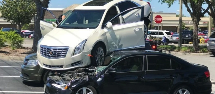 ¡Extraño accidente! En Florida un coche terminó encima de otros dos carros en un estacionamiento de un banco