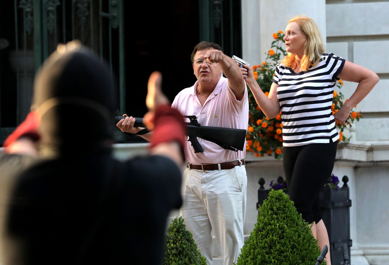 Matrimonio de raza blanca amenaza con armas , desde su mansión, a manifestantes