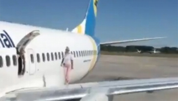 Pasajera abre puerta de emergencia y da un paseo por el ala del avión porque “tenía calor” (Video)